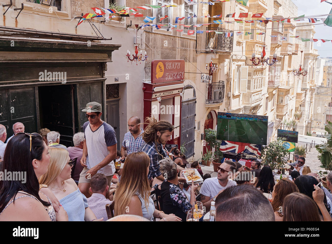 VALLETTA, MALTA - 24. JUNI 2018: Malteser Fans gucken Fußball Match auf Valletta Straße in der Hauptstadt von Malta in Sports Pub außerhalb Stockfoto