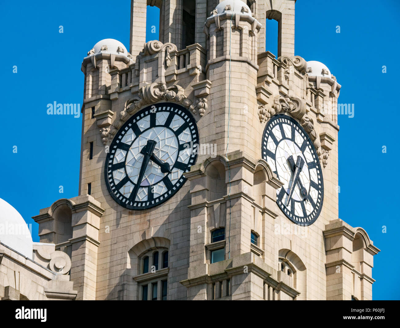 Nahaufnahme eines der Drei Graces, Royal Lever Building, Pier Head, Liverpool, England, Großbritannien mit den größten Uhren im Vereinigten Königreich und blauem Himmel Stockfoto