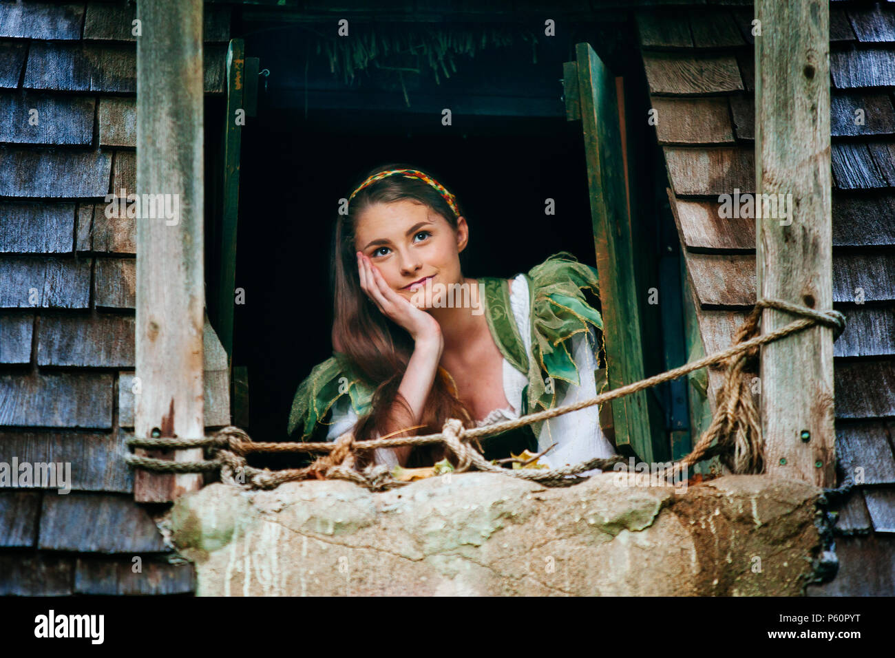 Eine Renaissance Faire Schauspieler maiden schaut aus dem Fenster ihres irischen Cottage Stockfoto
