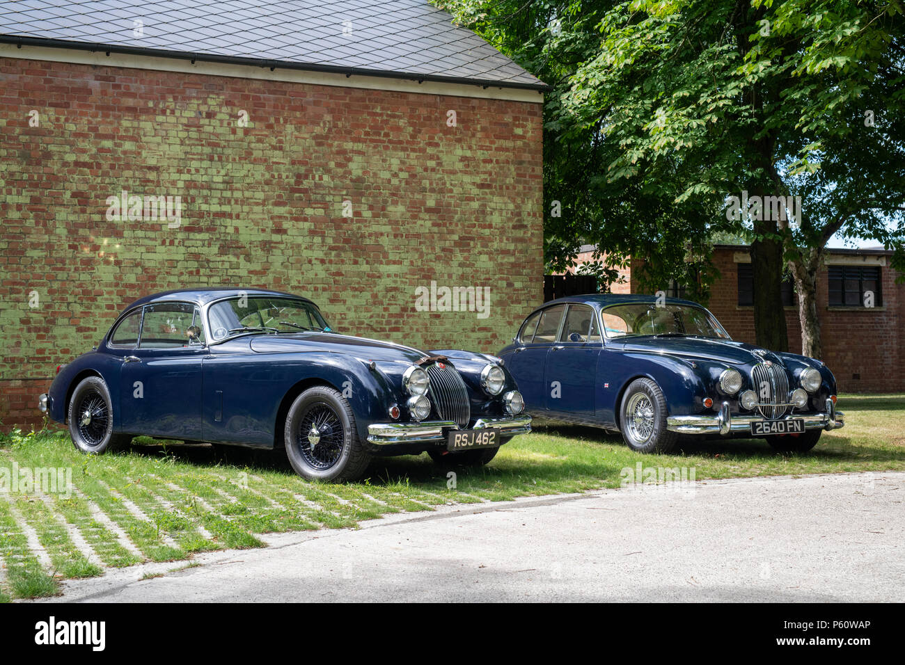 1959 Jaguar XK und ein 1962 Jaguar MK II im Bicester Heritage Center. Oxfordshire, England Stockfoto