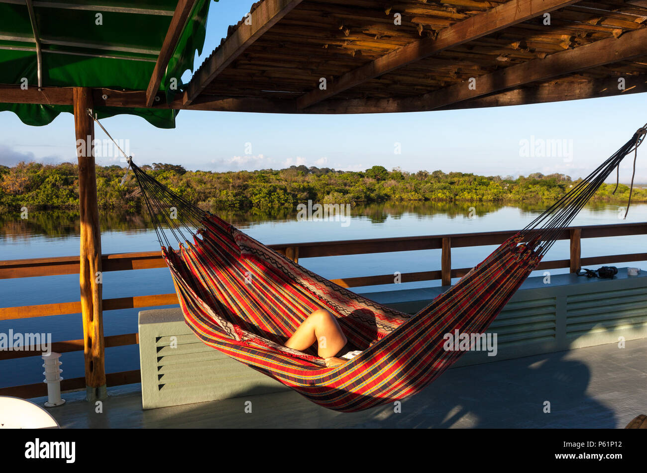 Amazonas, Brasilien. In einem Boot ein Tourist in einer Hängematte auf dem  Rio Negro Fluss im Amazonas liegt Stockfotografie - Alamy