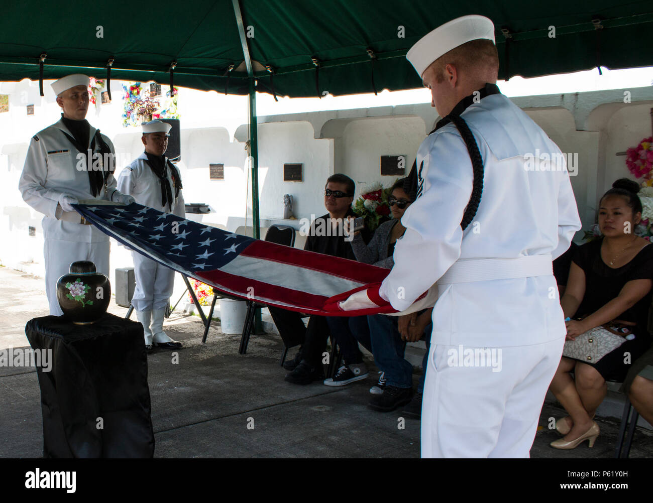 SANTA Rita, Guam (1. April 2016) - Master at Arms 1. Klasse Robert Schmidt (rechts) und Aviation Ordnanceman 1. Klasse James Stone Falten der Flagge für die Präsentation in der Familie. Drei Segler und Flieger aus der gemeinsamen Region Marianen (Jrm) Beerdigung Ehrungen durchgeführt bei einer Beerdigung für eine Guam Veteran, am 1. April an der Guam Veteranen Friedhof. Segler und Flieger widmen ihre Zeit zum Ehren zu Veteranen und ihre Familien bei Begräbnissen auf der Insel zur Verfügung zu stellen, die Durchführung von durchschnittlich vier pro Monat. (Erschienen/Jeff Landis, Major, USMC (Ret.), Direktor für Öffentliche Angelegenheiten/Kommunikation, Naval Ba Stockfoto