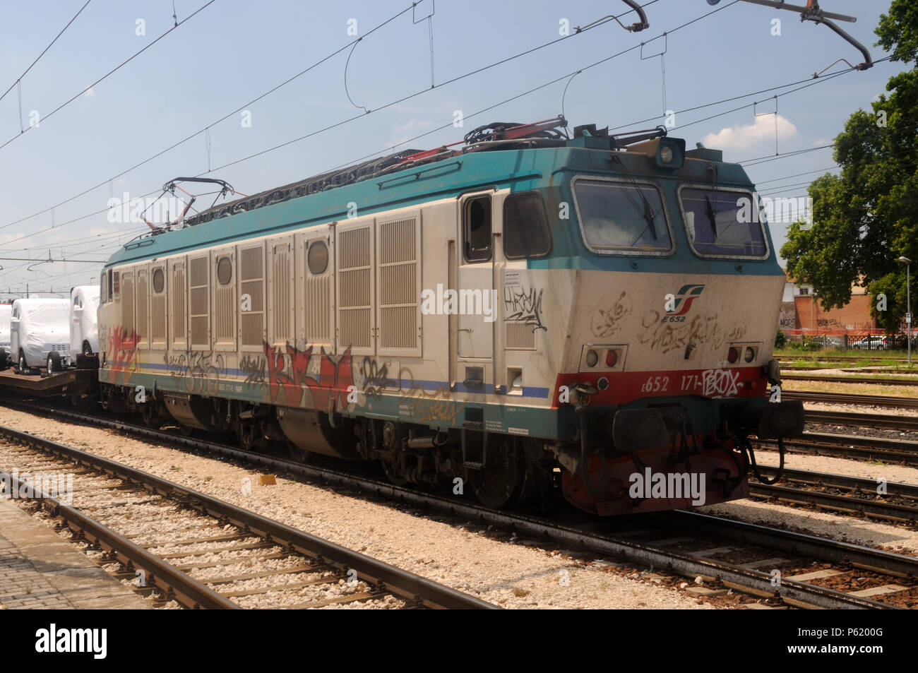 Ein Trenitalia Klasse E.652 elektrische Lokomotive steht an der Spitze eines Zuges mit Fiat Fahrzeuge am Bahnhof in Ferrara, Emilia-Romagna, Italien geladen Stockfoto