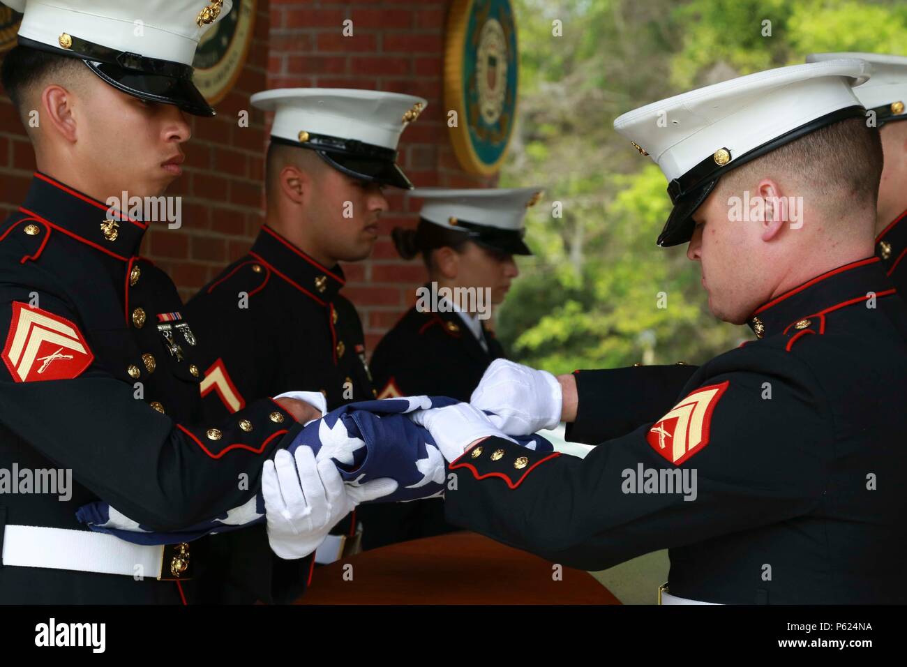 In der Saint Helena's Church in Beaufort, South Carolina, findet eine offizielle militärische Beerdigung statt, um einen Captain der U.S. Navy mit einunddreißig Jahren Dienst im Navy and Marine Corps zu ehren. Die Zeremonie umfasst einen Kaplan, eine militärische Ehrenwache, eine Flaggenpräsentation und traditionelle militärische Riten. Die Teilnehmer, darunter Familie, Mitglieder des Dienstes und Vertreter der Gemeinde, nehmen an der Ehrung des Kapitäns, seiner Führung und seinen Beiträgen für die Streitkräfte teil. Stockfoto