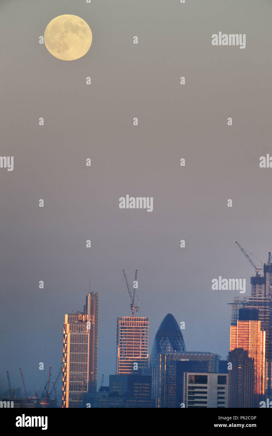 Die Aussicht von den Parliament Hill in Hampstead, London der Mond über der Stadt London steigt, vor dem Vollmond am frühen Donnerstag Morgen, die als Erdbeere Mond bekannt ist. Stockfoto