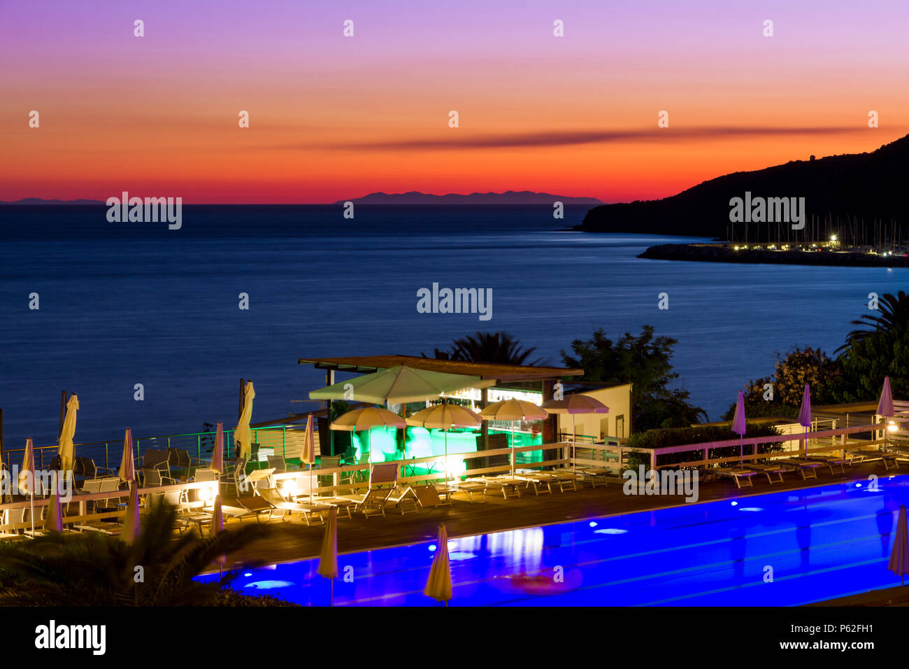 Einen Pool und eine Bar am Meer bei Sonnenuntergang im Sommer in Piombino vor der Insel Elba, Italien Stockfoto