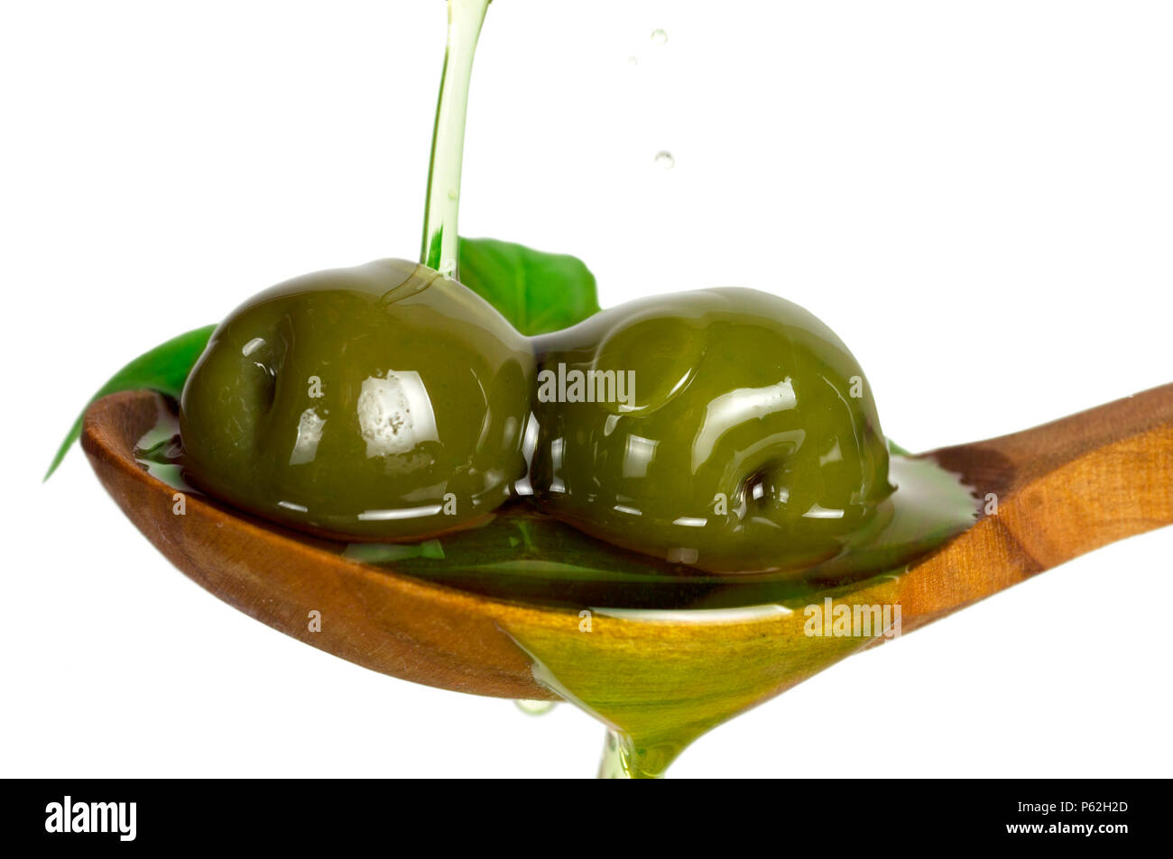 Rote Oliven in Öl mit Rosmarin über Löffel. Füllen Sie Öl auf Löffel auf weißem Hintergrund. Stockfoto