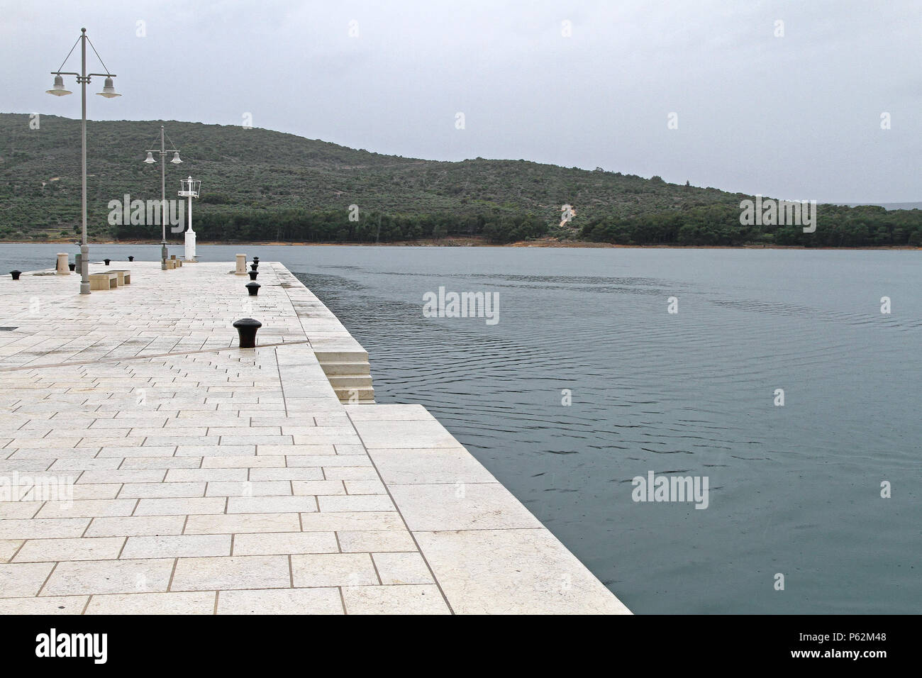 Regentag in weißem Marmor Stein Pier in Insel Cres Stockfoto