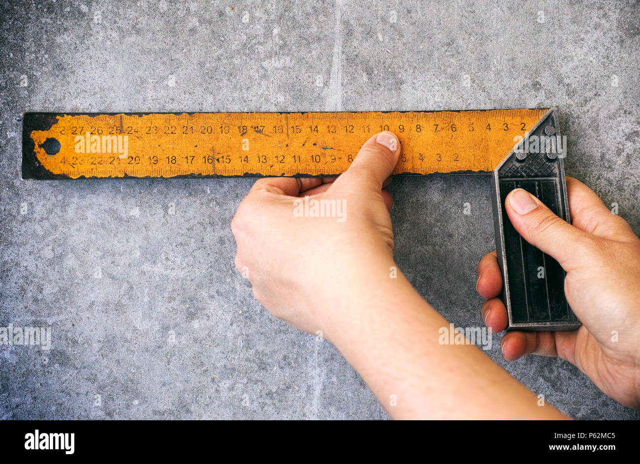 Person mit setsquare auf graue Wand. Close-up. Stockfoto