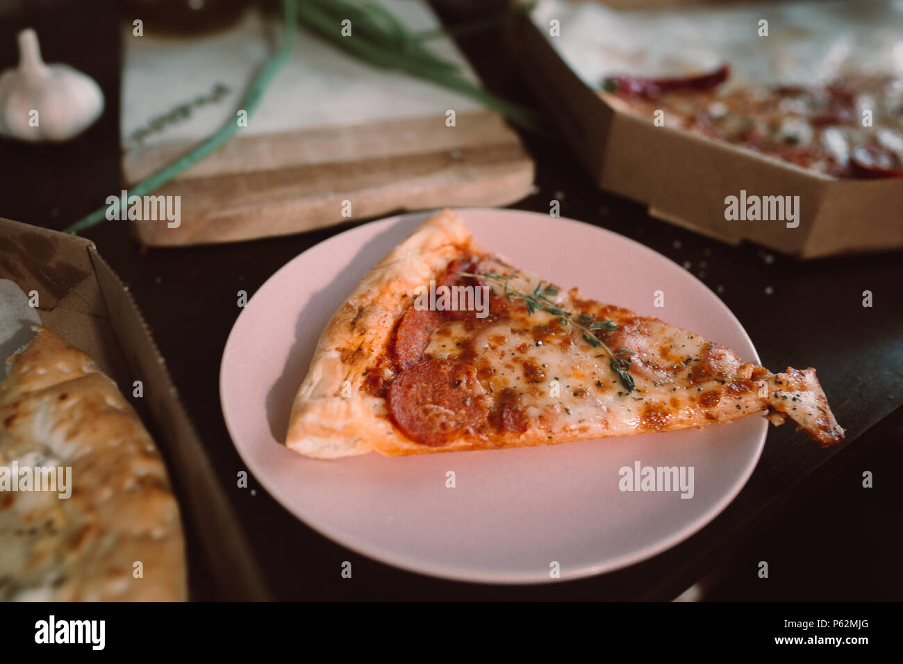 Stück Pizza auf Holztisch mit hellen Platten für die Partei. Dunklen rustikalen Toning essen Foto. Top Bild anzeigen. Stockfoto