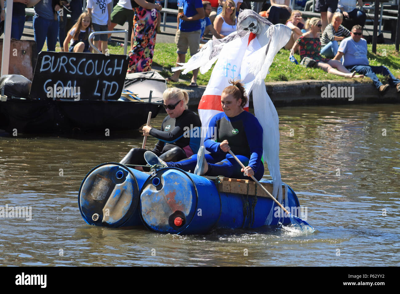 Ein Team von zwei Damen in einem raft Race konkurrieren auf einem Floß namens "Steife Ripples" entlang der Leeds und Liverpool canal zwischen der Helling Pub und Burscough Stockfoto