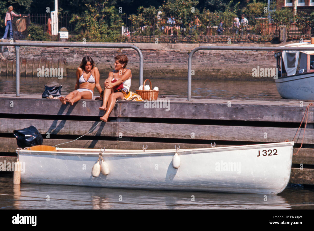 Zwei Frauen sitzen auf einem Steg chatten, Oulton Broad, Suffolk, England, 1975 Stockfoto