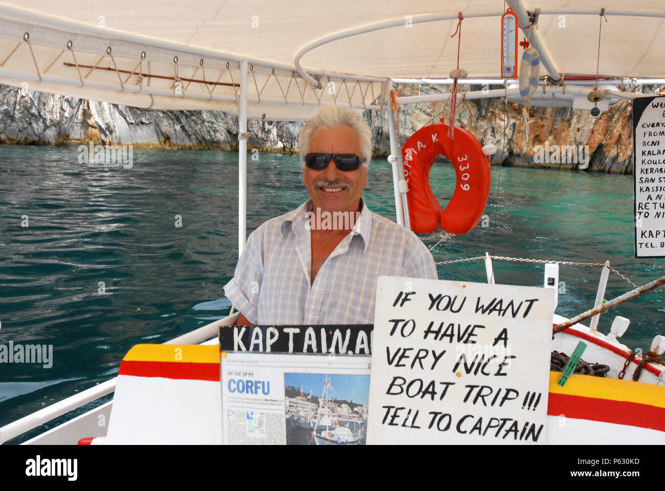 Kapitän der kleine, privat geführte Handwerk am Steuer seines Bootes posieren Stockfoto