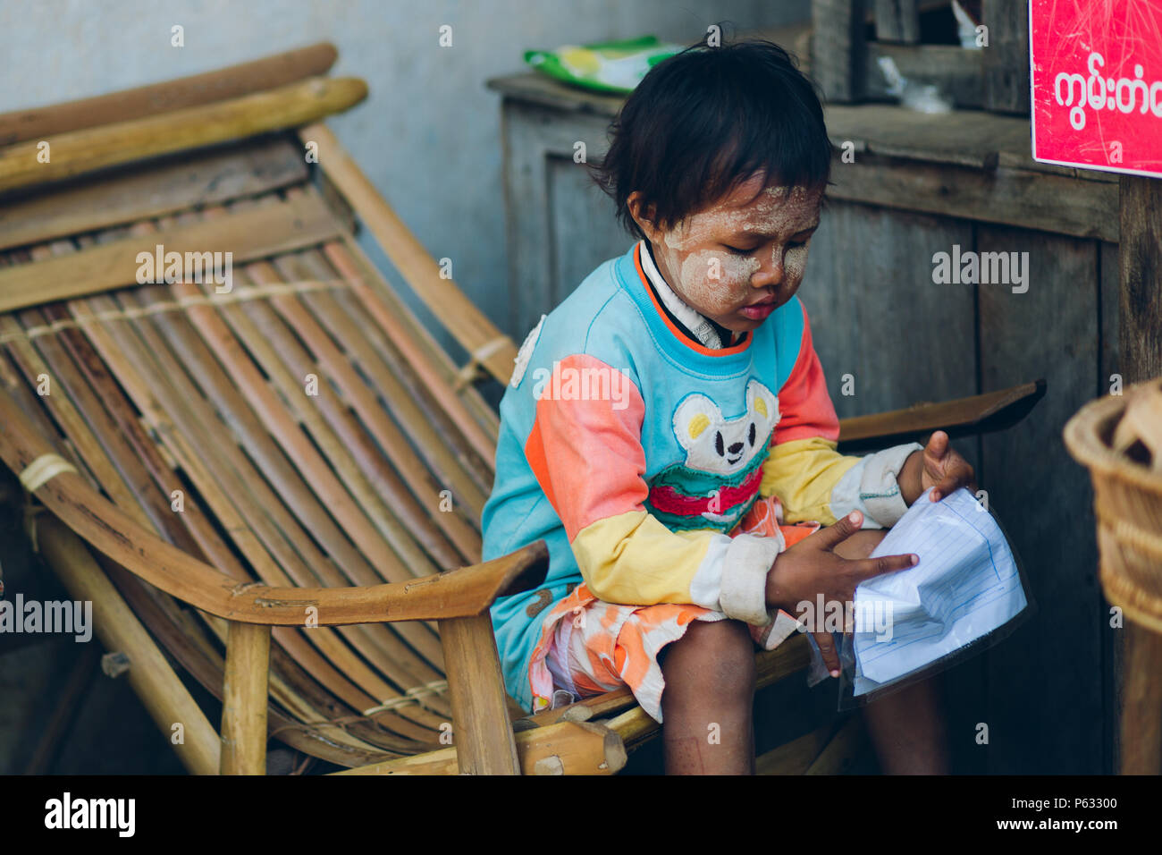 Bagan, Myanmar - Feb 21 2014: Porträt der jungen asiatischen burmesischen Mädchen zu Hause lesen als lokale Shop Stockfoto
