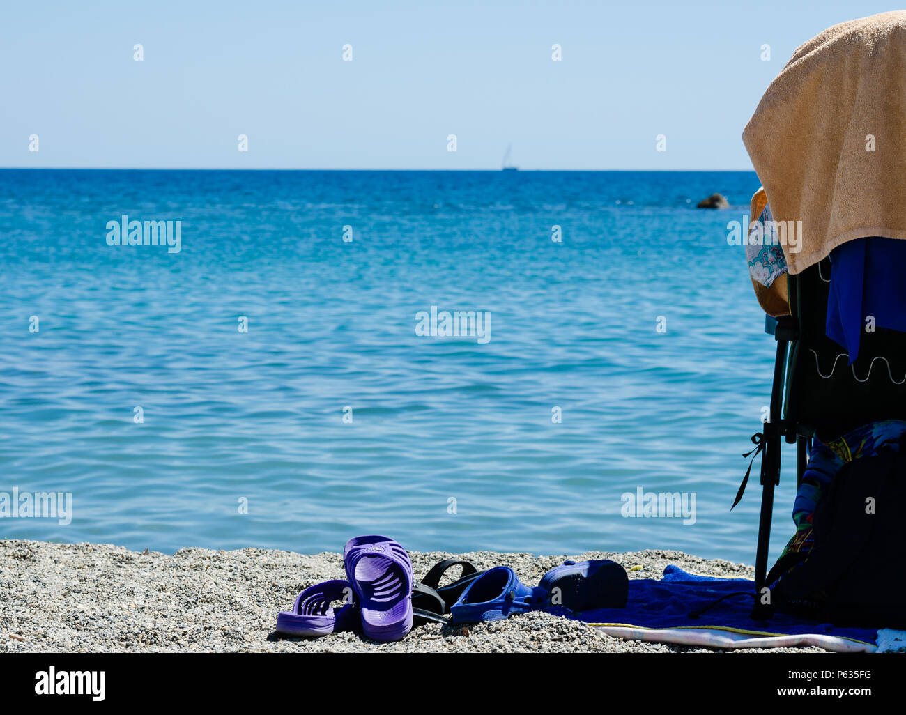 Verschiedene Badeschuhe am Strand. Badeschuhe zwischen dem Strand und dem Meer. Zur Anzeige einer warmen Sommer im Urlaub am Strand Stockfoto