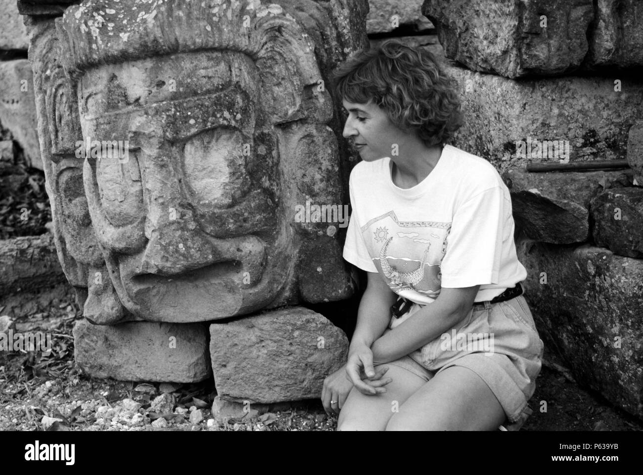 Touristen mit antiken Maya-Steinkopf, wahrscheinlich ein Gott oder Herrscher, fand bei den COPAN Ruinen - HONDURAS Stockfoto