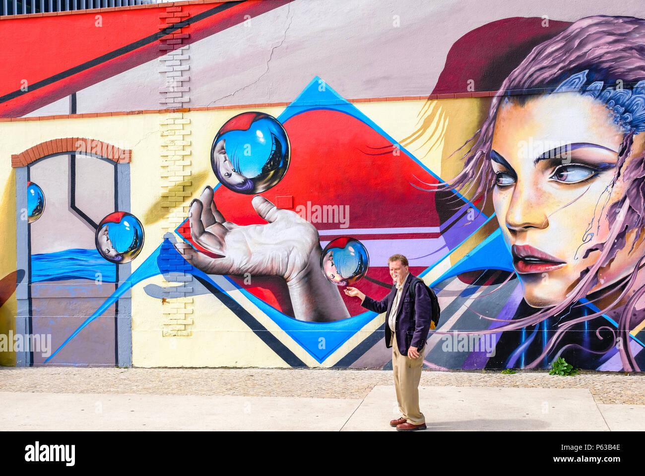 Schöne Graffiti von einer Frau mit einem Ball mit den Fingern; älteren Menschen imitiert die Malerei; Lissabon, Portugal Stockfoto