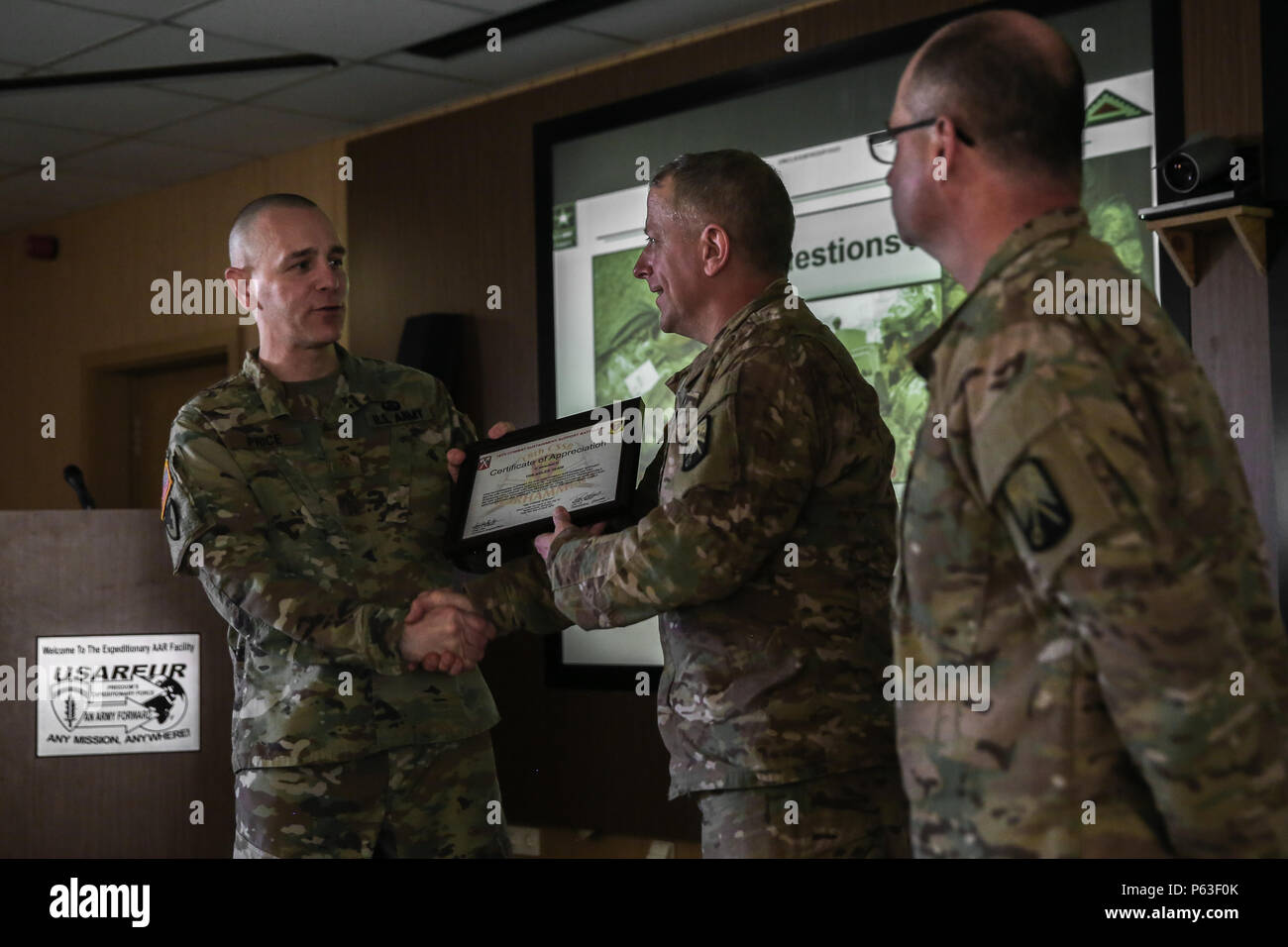 Ein US Soldat der Joint Multinational Readiness Center (JMRC), (Operations) Adler Beobachter Training Team Trainer erhält eine Bescheinigung der Anerkennung im Namen seines Teams für ihre Hilfe beim Abschluss bei der US Army Joint Multinational Readiness Center (JMRC) in Hohenfels, Deutschland, 20. April 2016 eine Überprüfung der Maßnahmen während der Übung Sabre Kreuzung 16. Sabre Ausfahrt 16 ist der US-Armee in Europa 173rd Airborne Brigade Combat Training Center Zertifizierung des JMRC in Hohenfels, Deutschland, Mar.31-Apr.Ort 24, 2016. Die Übung ist so konzipiert, dass t bewerten Stockfoto