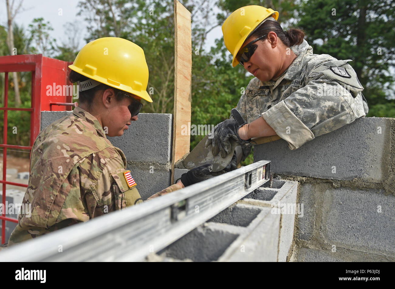 CATARINA, Guatemala - US Army Reserve SPC. Maria Almanza, (links) und SPC. Irene Jou-Saavedra, 284 Mitarbeiter, verteilt auf eine Schicht Mörtel Zinder-block, den 30. April 2016 während der Übung über den Horizont 2016 GUATEMALA. Die Soldaten verteilt der Mörtel gleichmäßig für die nächste Schicht von Asche Block zu ermöglichen Ebene zu legen und die Struktur Stabilität verbessern. (U.S. Air Force Foto von älteren Flieger Dillon Davis/Freigegeben) Stockfoto