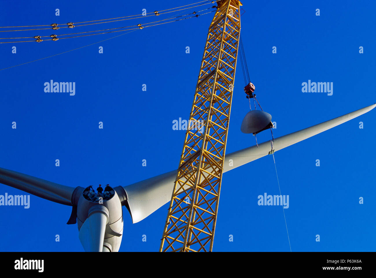 Zwei Arbeiter warten auf der Nabe eines riesigen ENERCON Windenergieanlage bereit, die Nase, die angehoben wird. Worksop Großbritannien. Deze Stockfoto