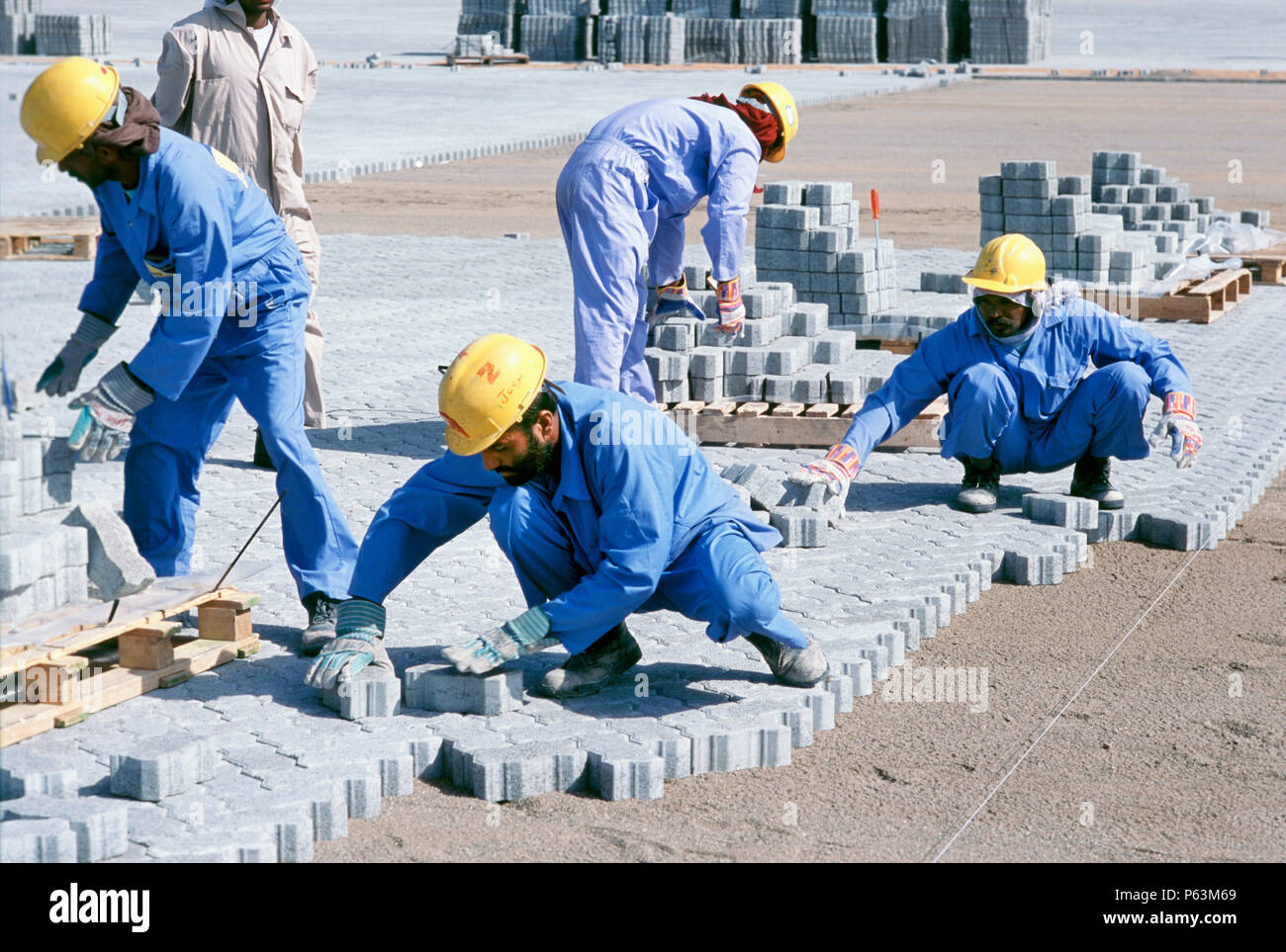 Bauarbeiter Festlegung block Wegbereiter für Container Stapelbereiche, Dubais Hafen Jebel Ali, Dubai. Stockfoto