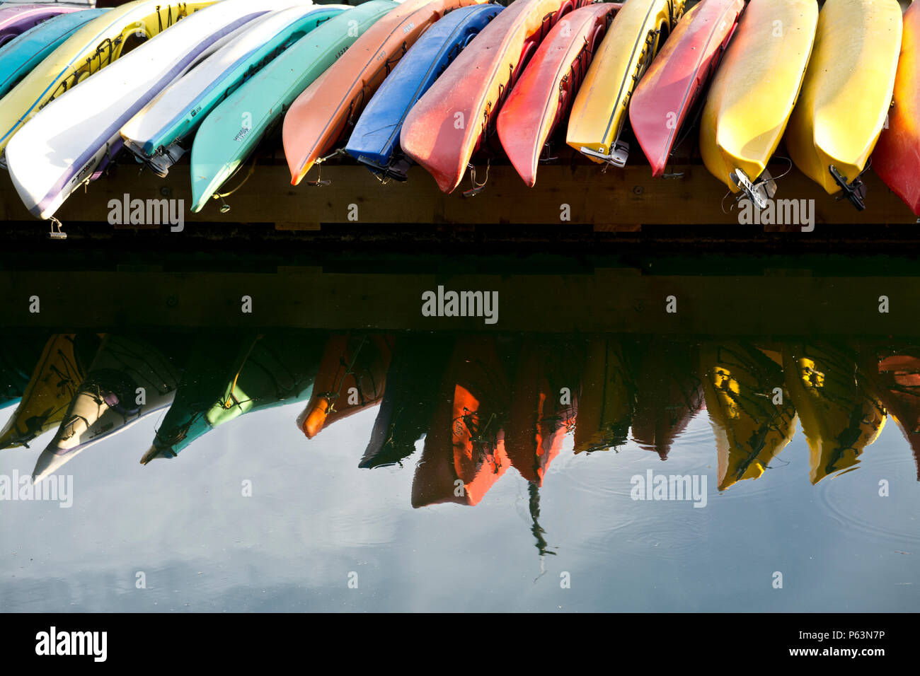 Bunte Kajaks aufgereiht auf der Anklagebank in Montague Hafen Marina auf Galiano Island, British Columbia, Kanada. Stockfoto