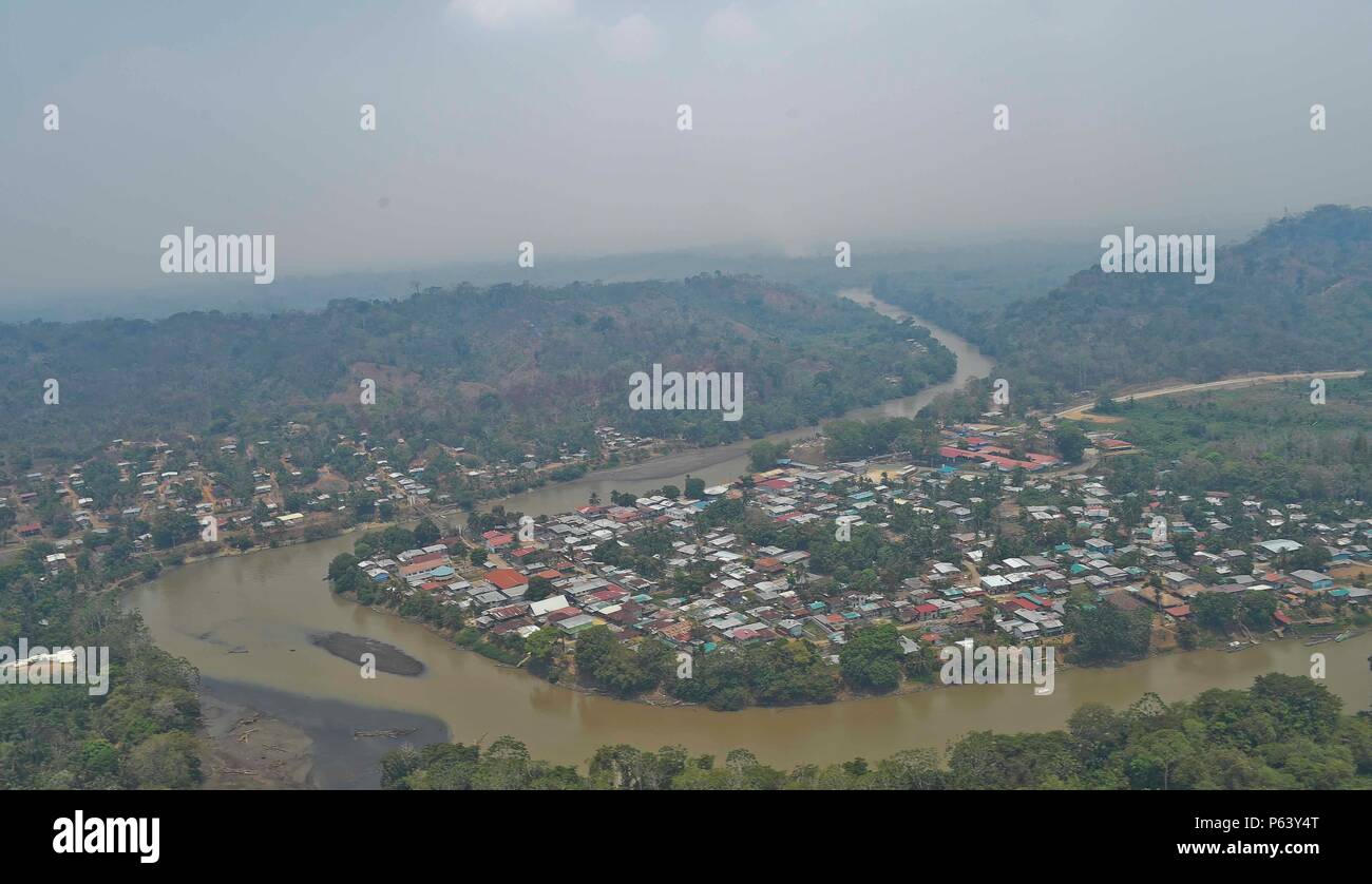 Eine Stadt in der Provinz Darién Panama sind Gemeinkosten, die sich aus einer gemeinsamen Aufgabe Force-Bravo Hubschrauber gesehen, mit Rauch aus einem wildfire, 18. April 2016. Mitglieder des JTF - Bravo mit Panamaschen öffentlichen Kräfte zusammengeschlossen, um mehrere lebensbedrohliche Waldbrände in der Region enthalten. Rund 45.000 Menschen in der Provinz Darién so die Ausbreitung des Feuers aus der unentwickelten Sumpfland und Wälder zu Wohngebieten befinden, war von größter Bedeutung. (U.S. Air Force Foto: Staff Sgt. Siuta B. Ika) Stockfoto