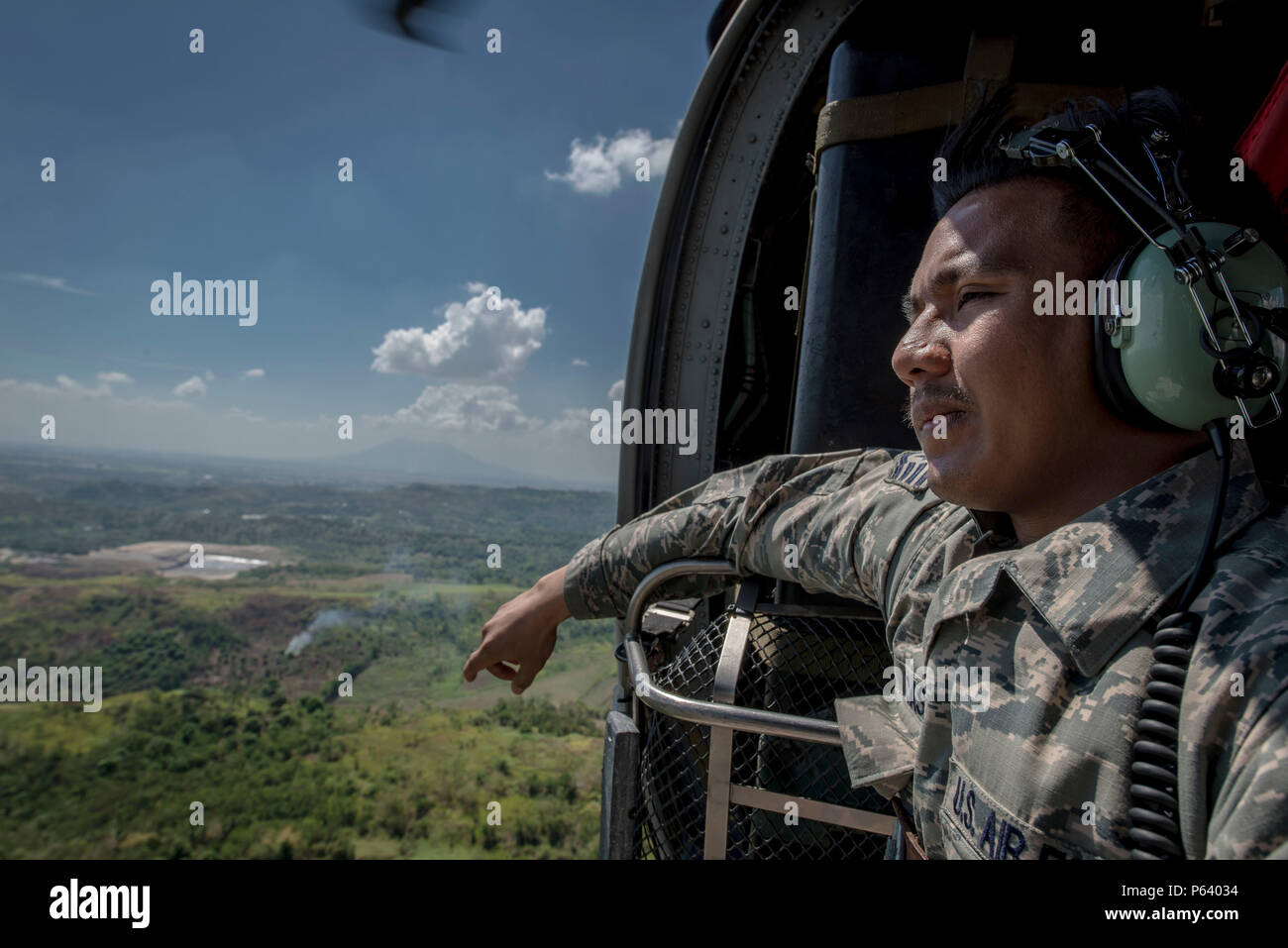 Us Air Force Staff Sgt. Jay Perocho Acasio, ein aircrew Flug Ausrüstung Facharbeiter mit der 51Th Operations Support Squadron, Osan Flughafen, Republik Korea, blickt über seine Heimat während einer HH-60G Pave Hawk Flug in der Nähe von Clark Air Base, Philippinen, 22. April 2016. Der staff sergeant ist einer von drei Filipino-American Flieger mit US Pacific Command neu Stand Luft bedingten in den Philippinen. Acasio ist von Ozamiz City in der Misamis Occidental, Philippinen. (U.S. Air Force Foto: Staff Sgt. Benjamin W. Stratton) Stockfoto
