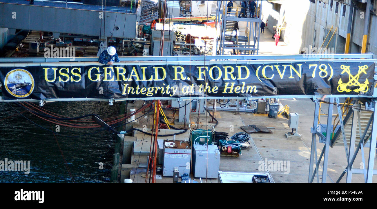 NEWPORT NEWS, Virginia, (8. April 2016) Pre-Commissioning Unit Gerald R. Ford (CVN 78) Sailor das Banner der Schiffsoffizier Stirn befestigt inspiziert. Dies war das erste Mal das Banner auf dem Schiff, das derzeit im Bau von Huntington Ingalls Newport News Shipbuilding angezeigt wurde. (U.S. Marine Foto von Mass Communication Specialist 1. Klasse Patrick Grieco/Freigegeben) Stockfoto