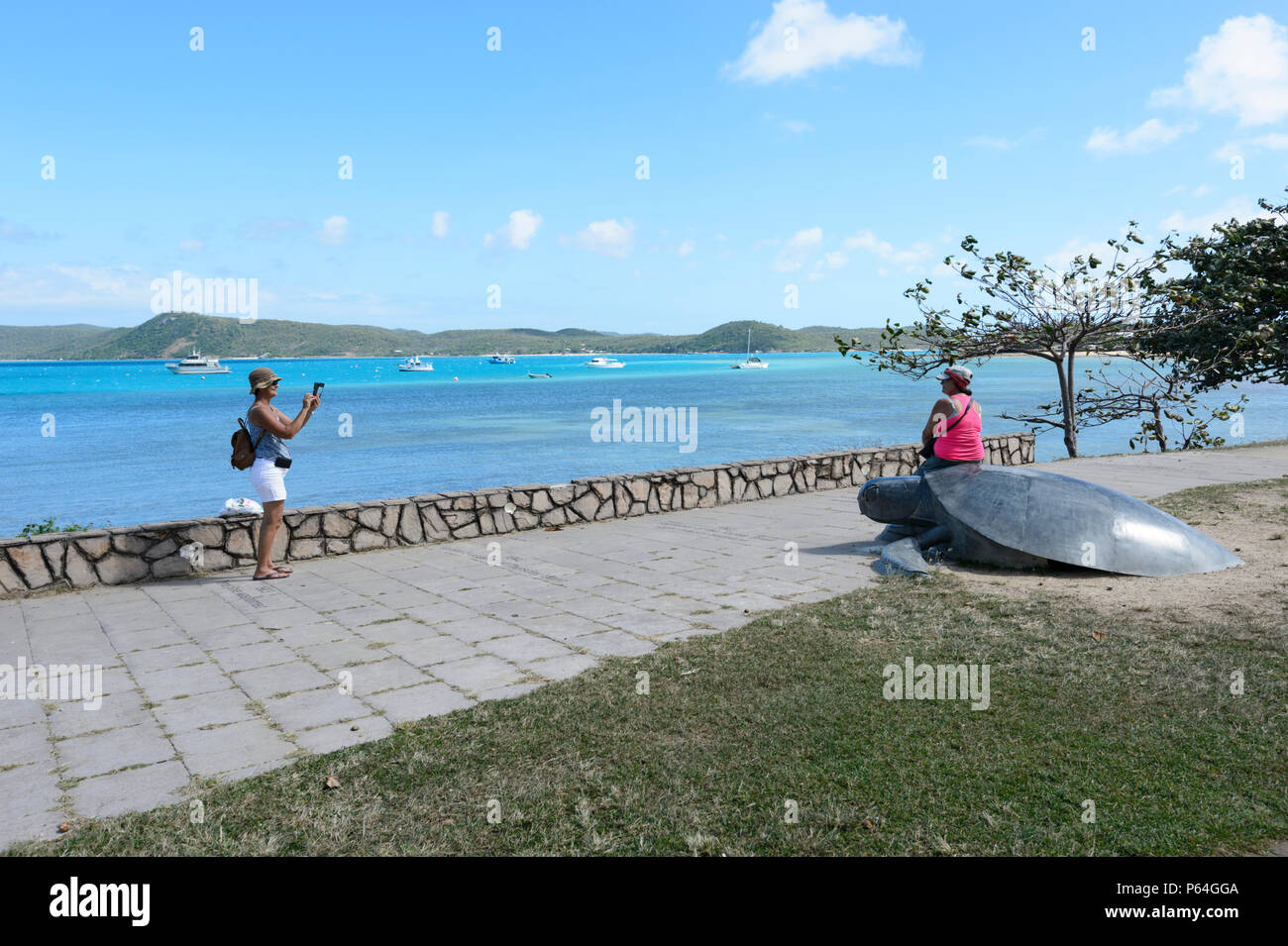 Touristische posiert auf einer Meeresschildkröte Skulptur auf der Victoria Parade Vorland, Donnerstag, Insel, Torres Strait Inseln, Far North Queensland, FNQ, QLD, Australien Stockfoto
