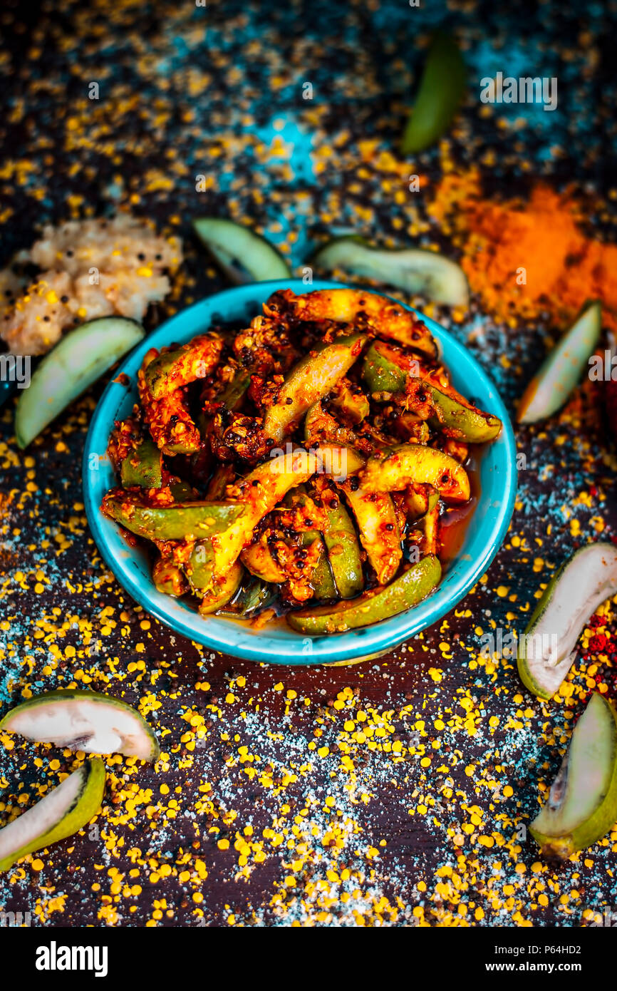 Nahaufnahme der Aam oder Kari ka ka achar achar mit all seinen Bestandteilen und speiceis auf einer hölzernen Oberfläche in drak Gotischen Farben. Stockfoto