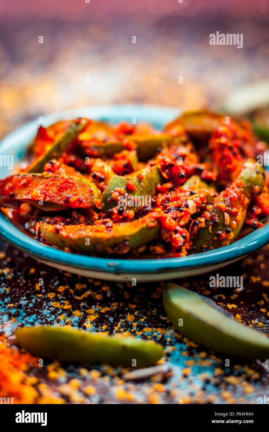 Nahaufnahme der Aam oder Kari ka ka achar achar mit all seinen Bestandteilen und speiceis auf einer hölzernen Oberfläche in drak Gotischen Farben. Stockfoto