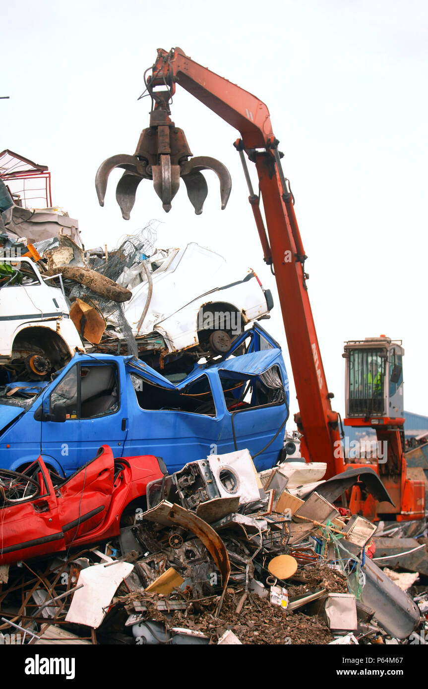 Mechanische Lader mit einem Enterhaken arm in einer Recyclinganlage am Anlegesteg in einem Hafen Newport, South Wales, Großbritannien Stockfoto