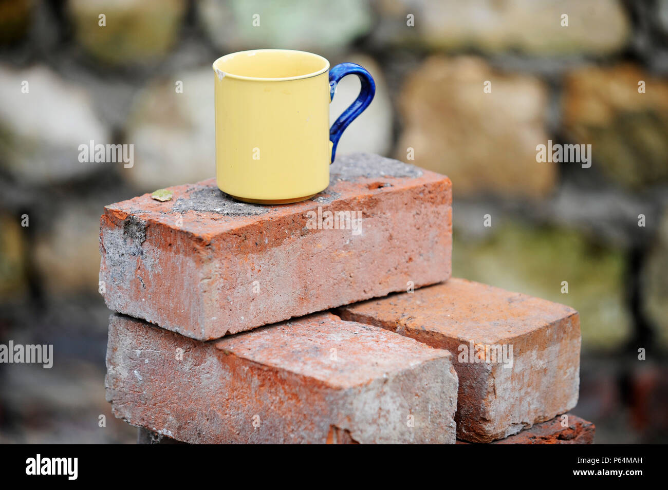 Ein Baumeister Becher Tee auf einem Stapel von aufgearbeiteten roten Ziegeln UK Stockfoto