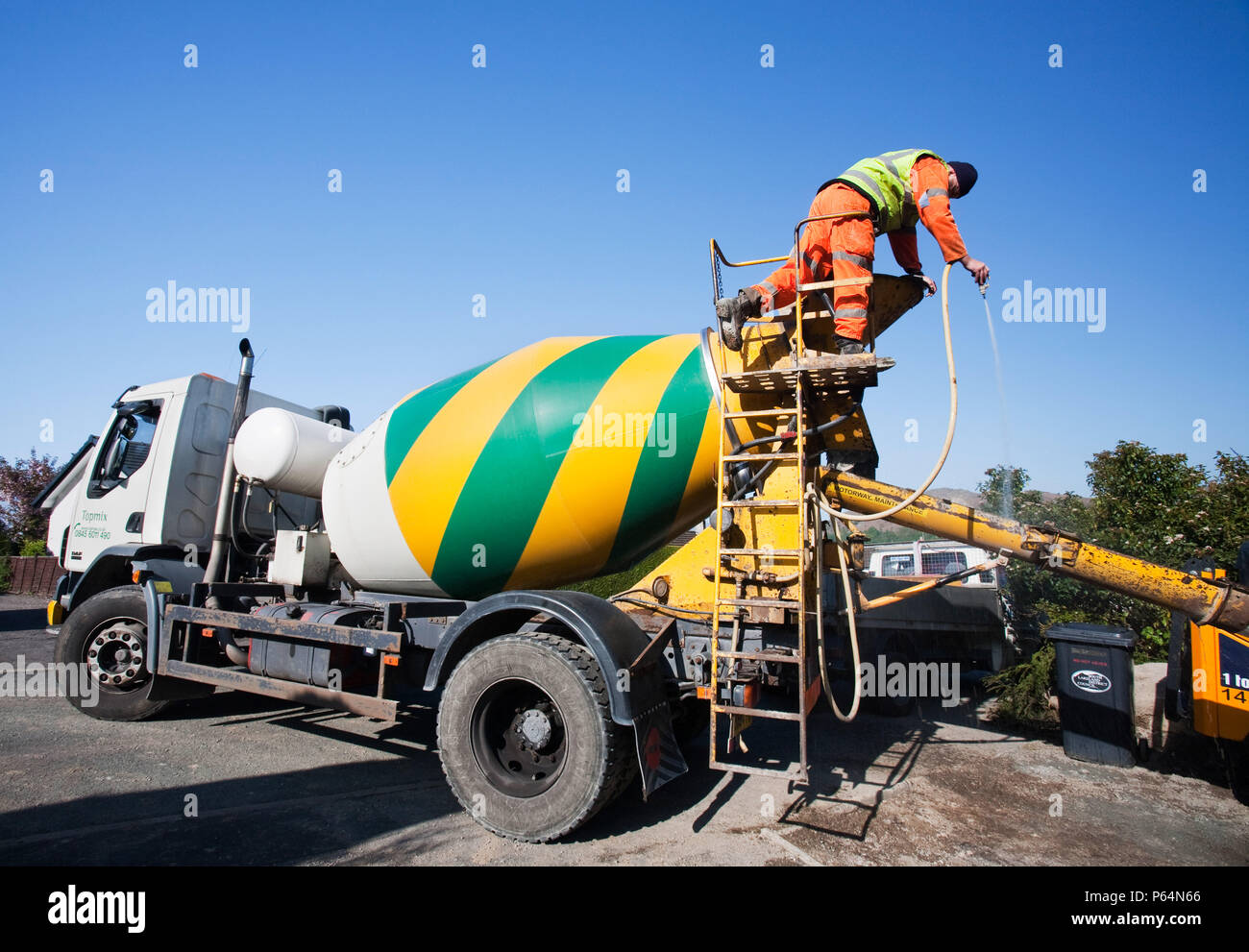 Eine konkrete Lieferung Mann wäscht heraus die Rutsche nach dem Gießen ein Mix aus Beton. Die Zementindustrie ist EINEDER die Carbon hungrig auf dem Planeten. Stockfoto