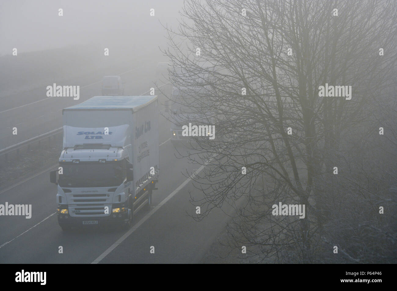 Der Verkehr auf der Autobahn im Winter mit gefährlichen dicker Nebel. Stockfoto