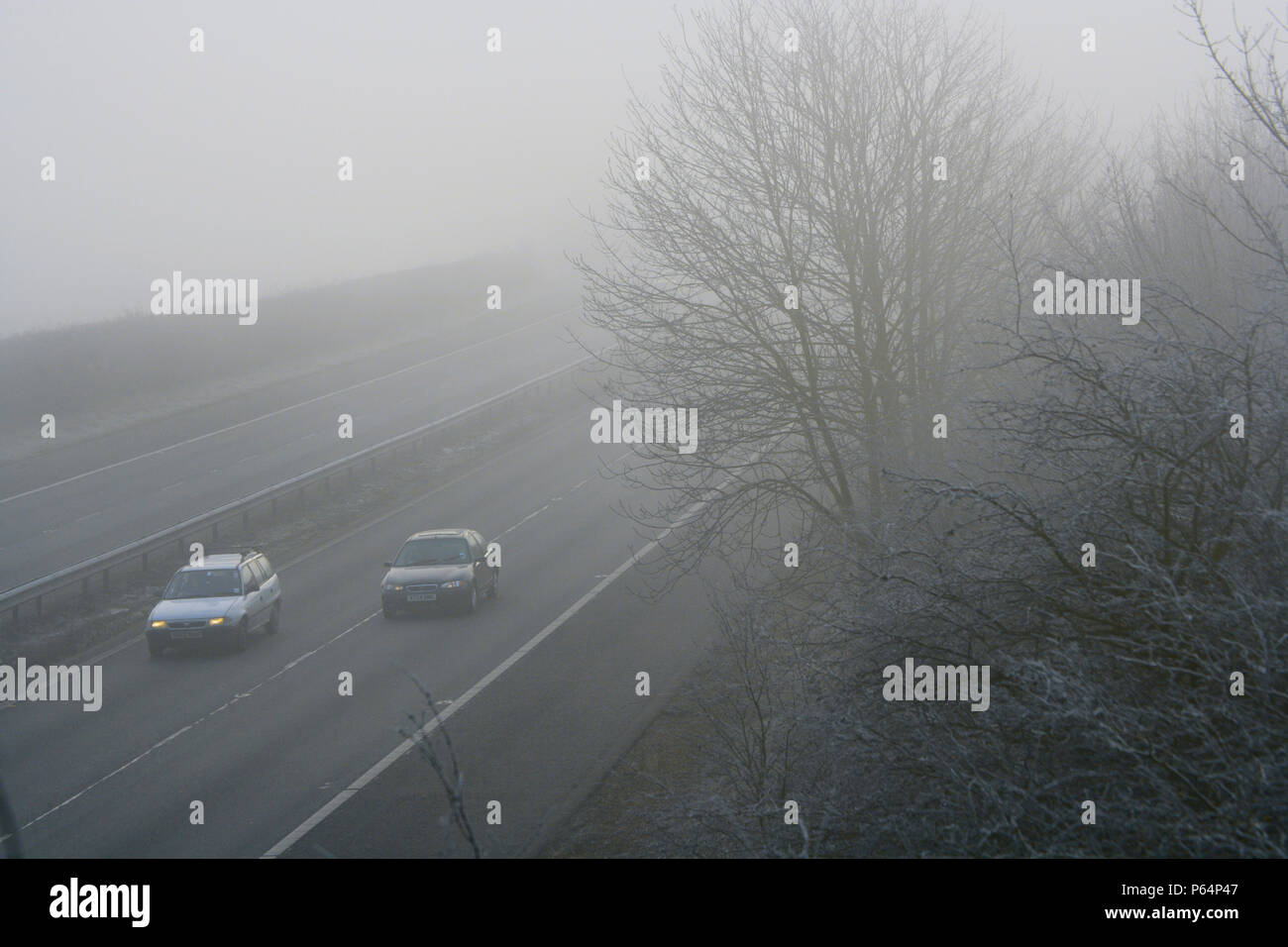Der Verkehr auf der Autobahn im Winter mit gefährlichen dicker Nebel. Stockfoto