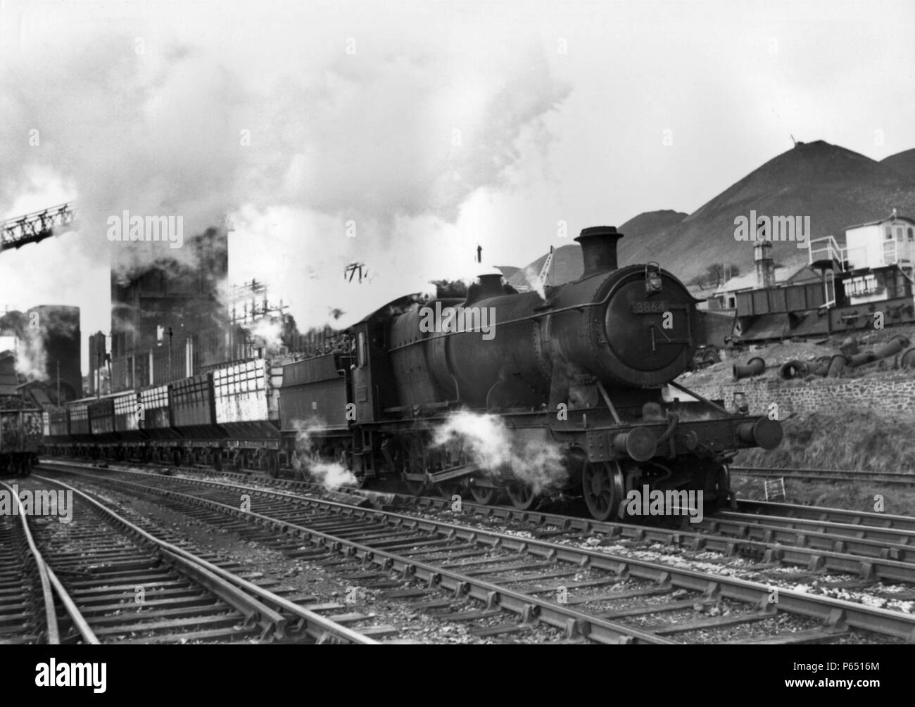 Eine schwere Kohle Zug fährt von einer Zeche auf der South Wales Reviers hinter einem Kirchhof 28 xx Klasse 2-8-0 im Jahr 1964. Stockfoto