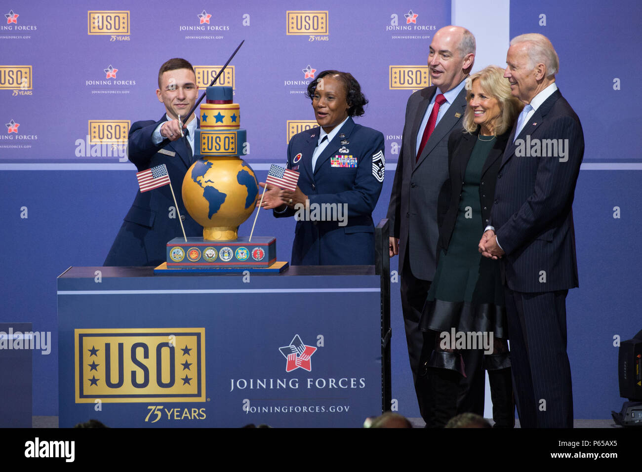 Einen Flieger schneidet den Kuchen zu Ehren des 75-jährigen Bestehens des USO in der Comedy Show in der Feier des 75. Jahrestages der USO und der 5. Jahrestag der Kräfte bei Joint Base Andrews in Washington D.C., den 5. Mai 2016. Auf der rechten Seite von der vorderen sind Vizepräsident Joe Biden, Dr. Jill Biden und USO Präsident J.D.Crouch. Die Bündelung der Kräfte ist eine Initiative Militärs, Veteranen und deren Familien gegründet von Dr. Jill Biden und der First Lady Michelle Obama zu helfen. (DoD Nachrichten Foto durch EJ Hersom) Stockfoto
