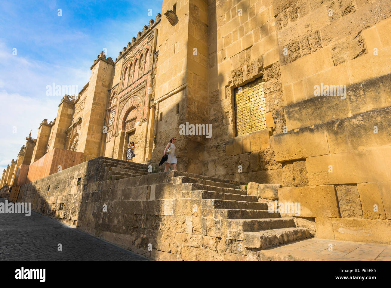 Spanien Andalusien reisen, eine junge Frau steigt Schritte entlang der Westwand des Großen Kathedrale Moschee (Mezquita) in Cordoba, Andalusien, Spanien. Stockfoto