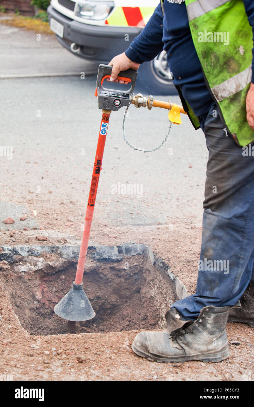 Ein British Gas Arbeiter mit Druckluft Boden picker Boden um utility Rohre als Teil einer Gasleitung Austausch upgrade zu lösen. Da introduci Stockfoto