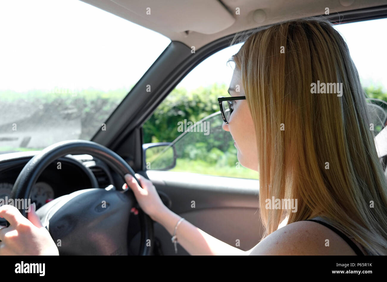 Weibliche jugendliche Fahrer, fahren Autos, Norfolk, England Stockfoto