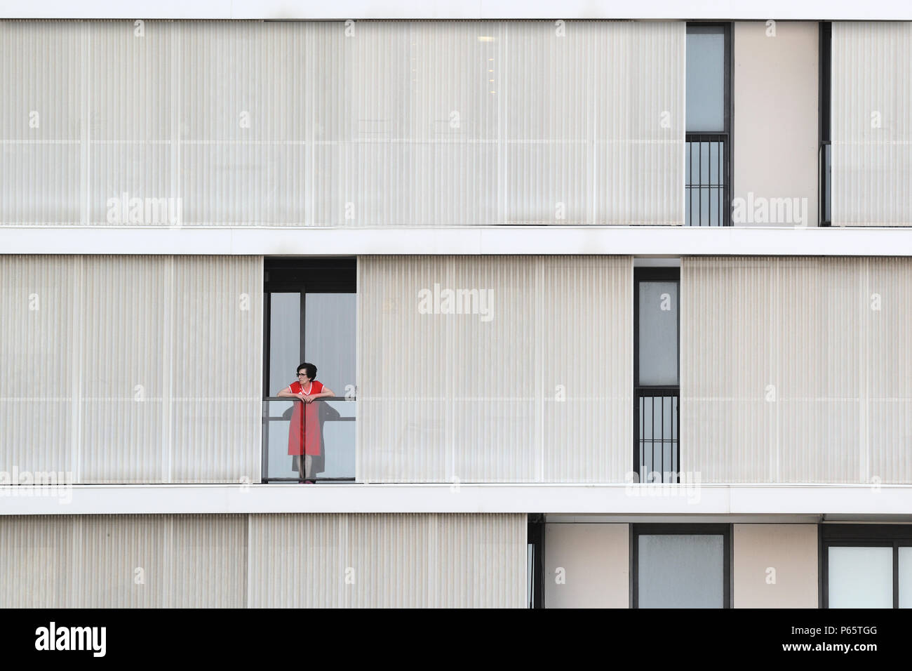 BARCELONA - Juni 28: Einsame Frau, stehend auf einem Balkon eines modernen Fassade, am 28. Juni 2018 in Barcelona Stockfoto