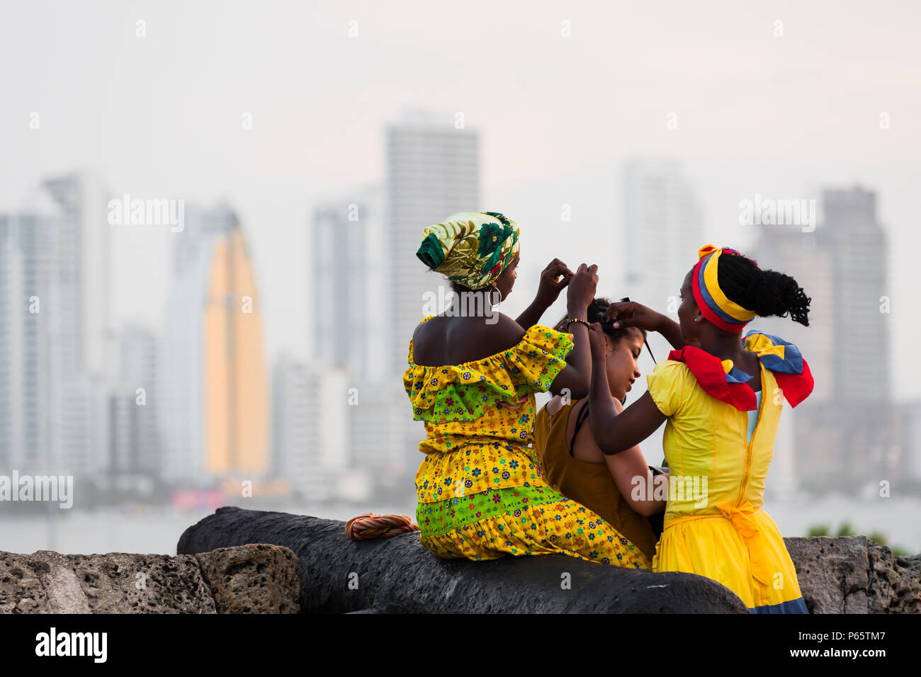 Afro-Mädchen, in die traditionelle "palenquera' Kostüm, erstellen Sie eine  geflochtene Frisur für Touristen, die an den Wänden in Cartagena, Kolumbien  Stockfotografie - Alamy