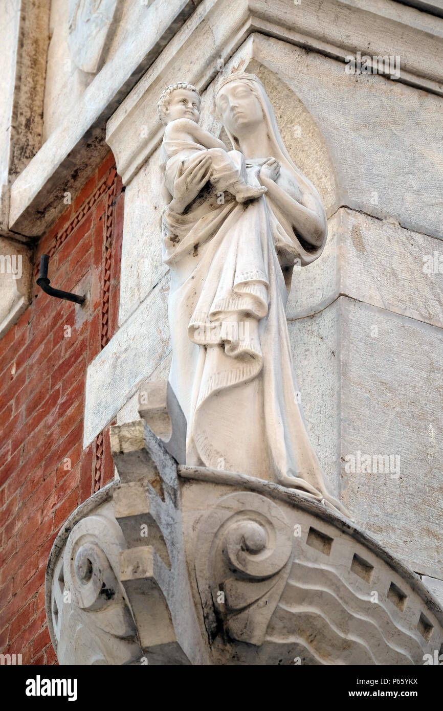 Statue der Jungfrau Maria mit dem Jesuskind auf der Hausfassade in Lucca, Toskana, Italien Stockfoto