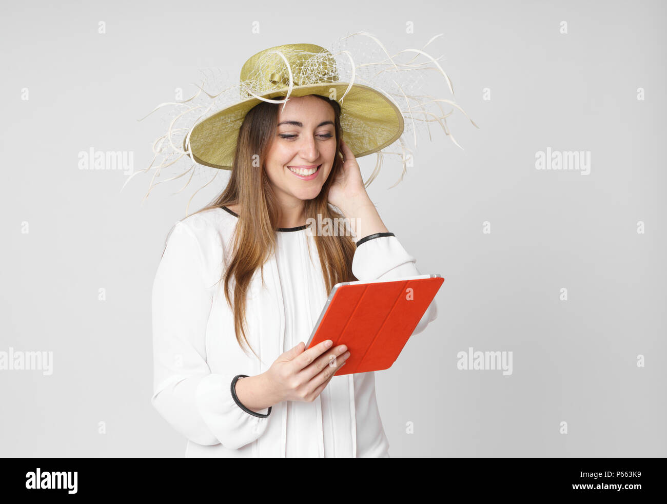 Frau mit Hut lesen tablet pc auf Weiß Stockfoto