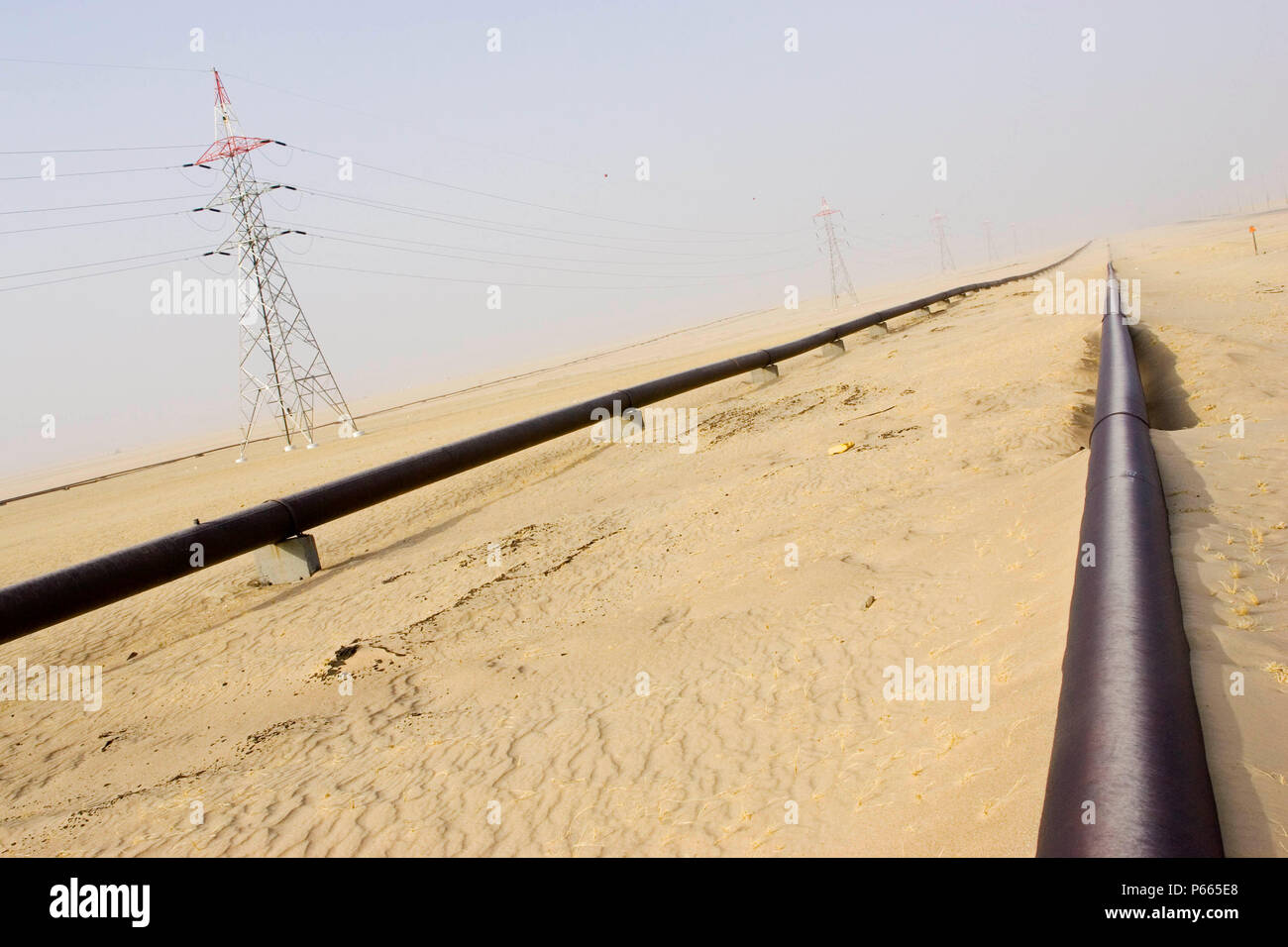 Pipeline- und Strommasten, die zu Kuwait City Stockfoto