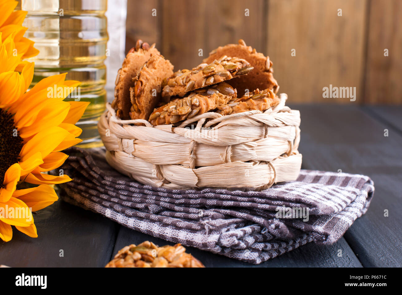 Öl dodsolnechnoe in eine große Flasche, ein Blumenstrauß aus Sonnenblumen Blumen, auf einem terned Hintergrund. Hausgemachte backen. Kekse mit Samen. Natürliches Produkt, rustikalen Stil. Platz kopieren Stockfoto