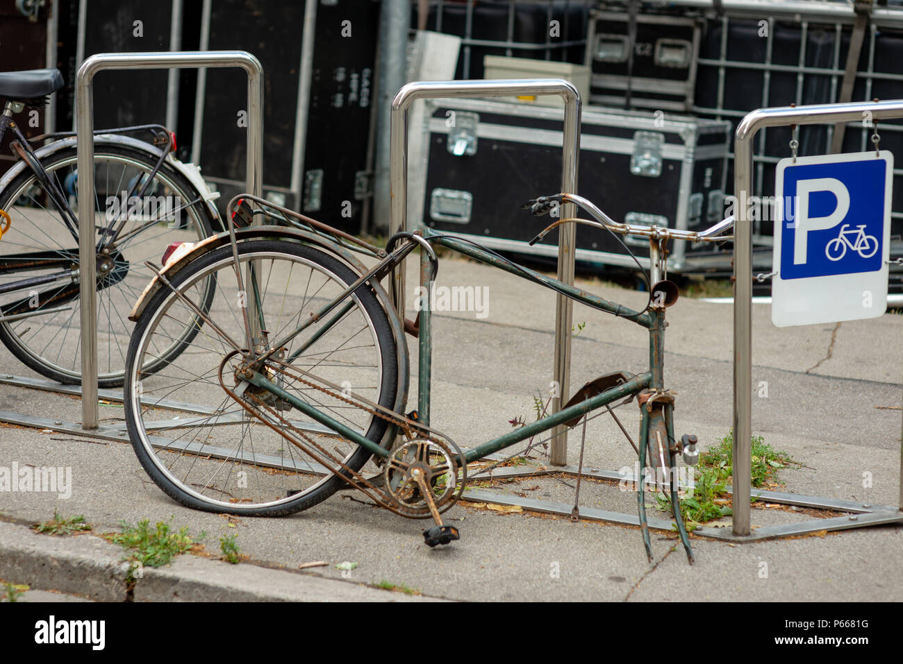 Eine beschädigte Fahrrad ist in einem fahrradständer gesperrt. Stockfoto