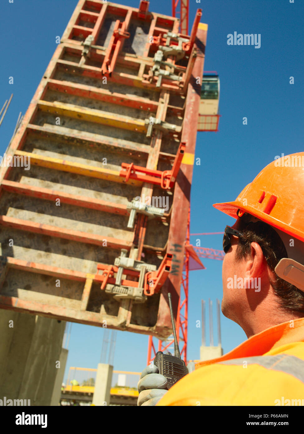 Mann mit Walkie talkie, Positionierung, glasfaserverstärkten (GRC) konkrete Panel Stockfoto